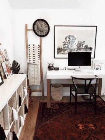 חדר עבודה ביתי של בוהו סקנדי עם שטיח בוהו, סלים, טקסטיל מודפס וגדילים ושולחן לבן מלא